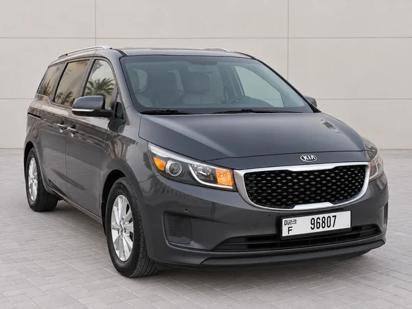 Dark grey Kia Carnival with driver in Dubai