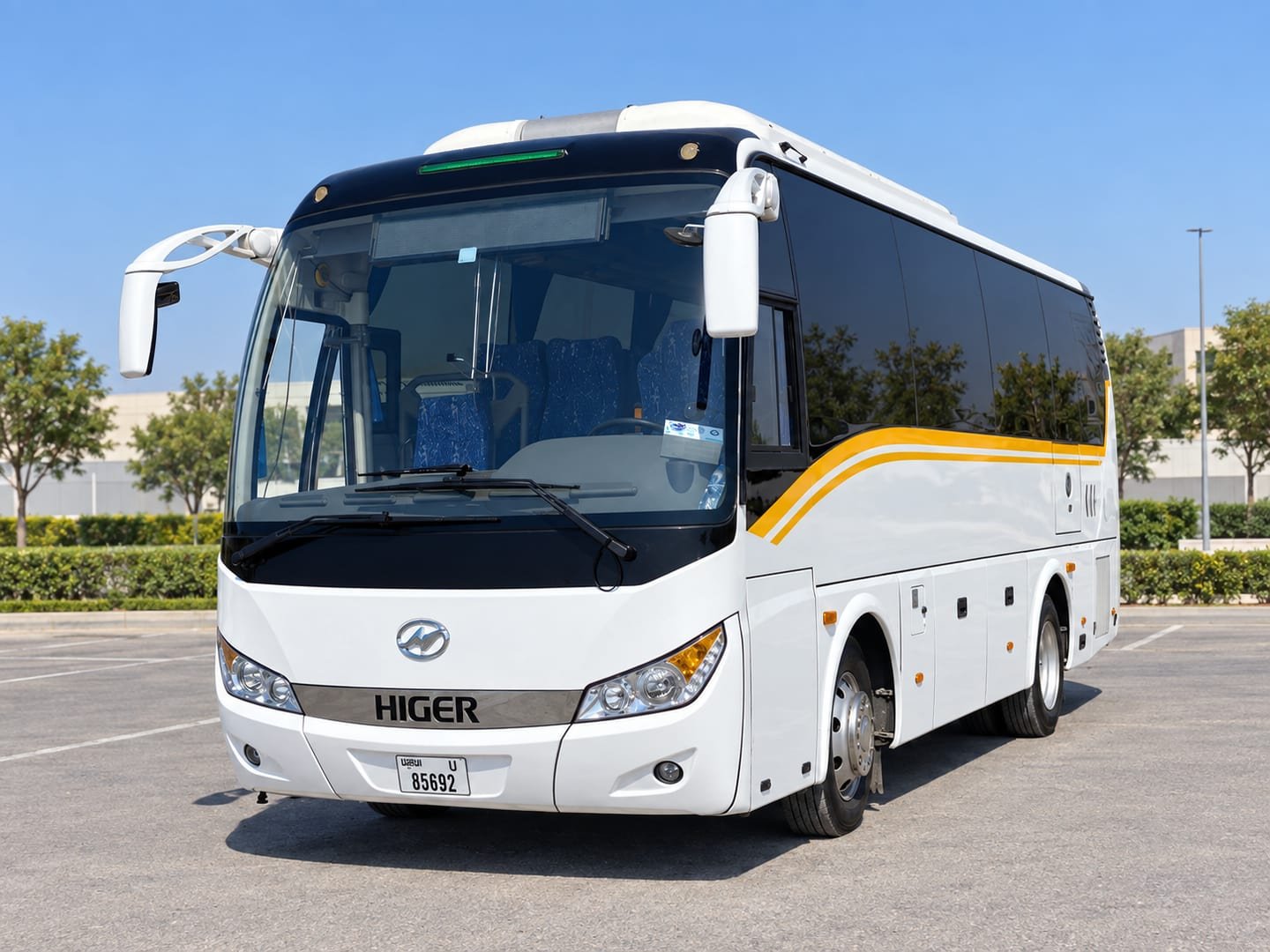 Front and driver-side view of a white Higer 35-seater coach with yellow stripes