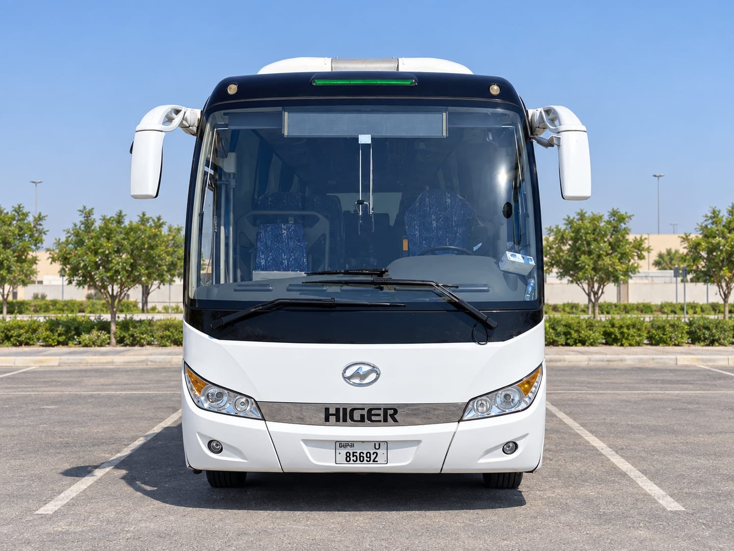 Front view of a white Higer coach with large windscreen and side mirrors