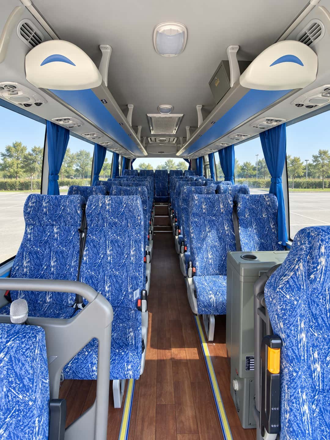 Higer coach interior with blue patterned passenger seats, centre aisle and overhead luggage racks