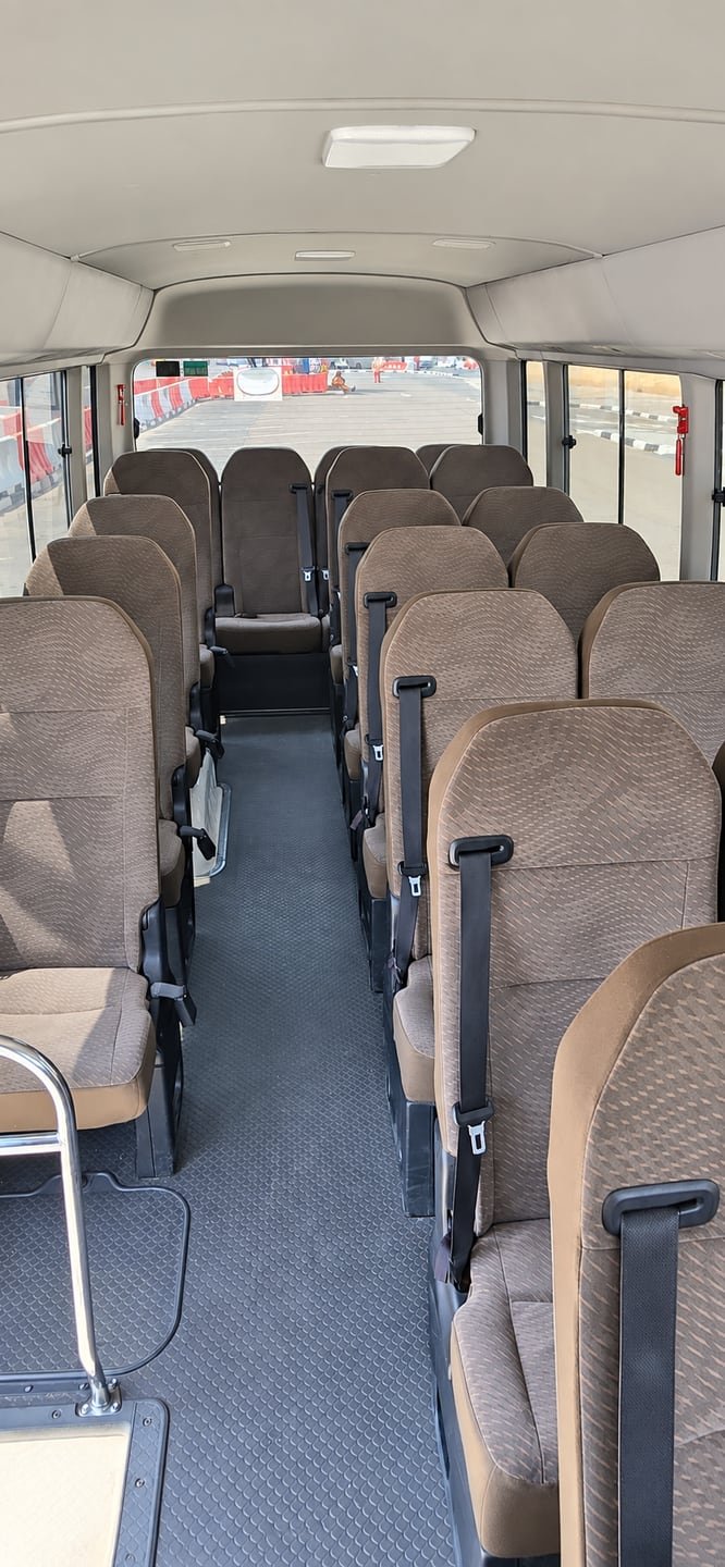 Centre aisle and brown passenger seats inside a Toyota Coaster minibus